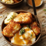 A vibrant bowl filled with crispy breaded chicken katsu sliced into strips, drizzled with rich tonkatsu sauce, served over steamed white rice and garnished with shredded cabbage and sesame seeds. The dish is styled simply on a rustic wooden surface, showcasing textures from the crunchy breading to glossy sauce, with a colorful backdrop highlighting the freshness.